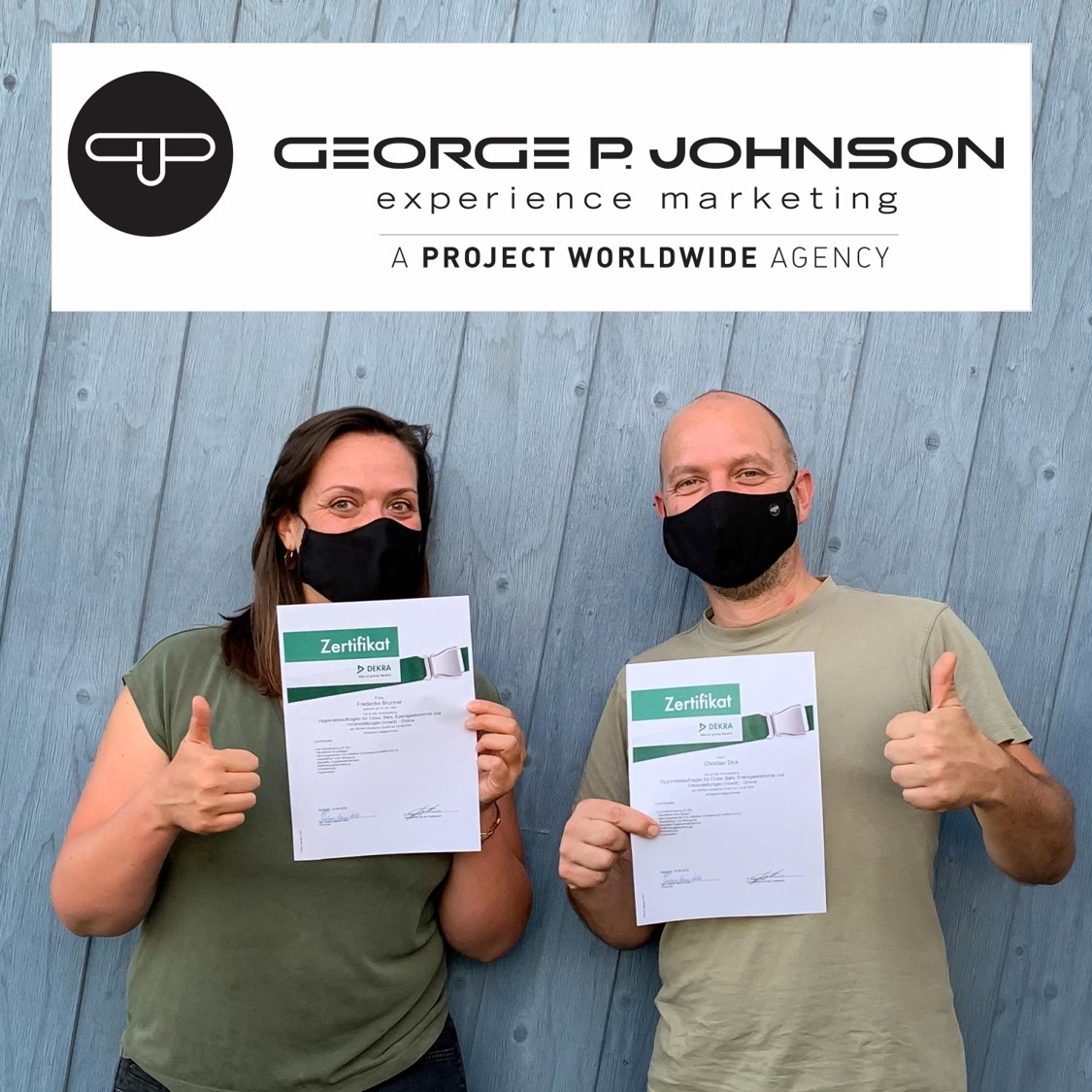 Zwei GPJ Mitarbeiter tragen eine Mund- und Nasenmaske und zeigen ihr Dekra Zertifikat für Hygiene