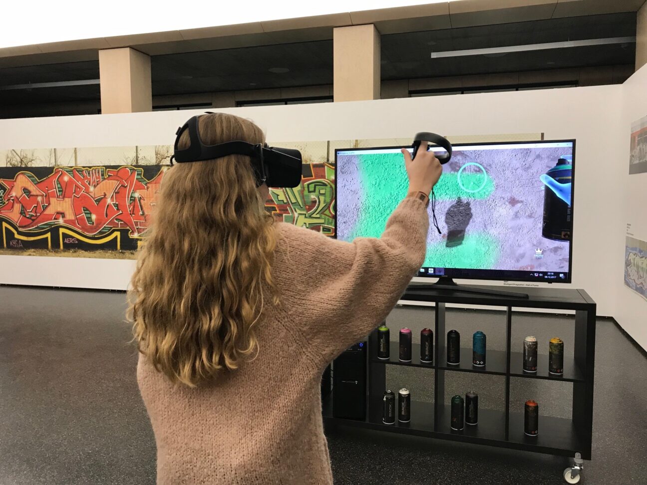 Besucher steht mit einer VR Brille vor dem Screen