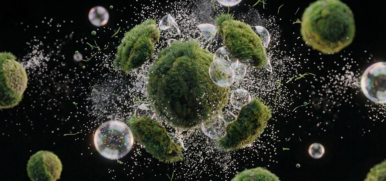 A bubble covered in grass bursts in the center of a dark background.